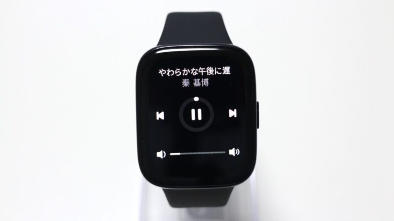 Redmi Watch 3 Activeの画面に、再生中の曲のタイトルやアーティストの情報が表示されている他、再生をコントロールするためのボタンがいくつか表示されている