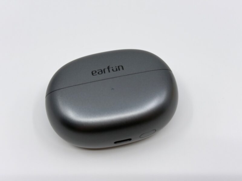 EarFun Clipの充電ケース（斜めから撮影）。メタリックグレイの表面は光の当たり方で色味が変わる